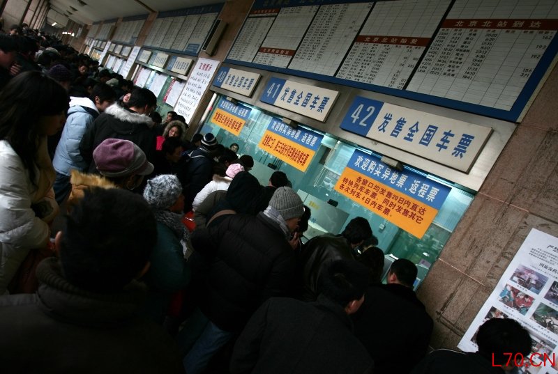 二十年前，春运买票意味着彻夜排队，图为2006年北京站售票窗口前买票的人们。摄影记者/王晓东